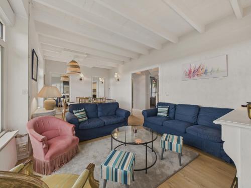 a living room with blue couches and a table at Superbe vue - Maison pour 6 - 650m de la plage in Trévou-Tréguignec