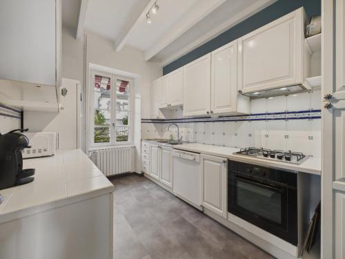 a kitchen with white cabinets and a stove top oven at Superbe vue - Maison pour 6 - 650m de la plage in Trévou-Tréguignec