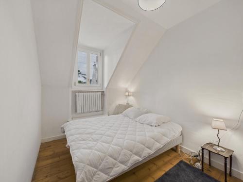 a white bedroom with a bed and a window at Superbe vue - Maison pour 6 - 650m de la plage in Trévou-Tréguignec