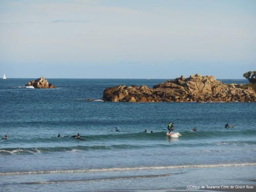 a group of people surfing on a wave in the ocean at Superbe vue - Maison pour 6 - 650m de la plage in Trévou-Tréguignec