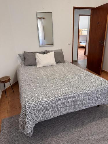a bedroom with a large bed with a mirror at Surf Seixe Guest House in Odeceixe