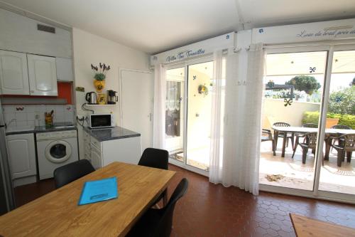 Il comprend une cuisine, une salle à manger avec une table et une cuisine. dans l'établissement Villa Tao a quelques pas de la plage, à Torreilles