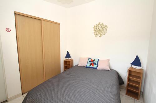 une chambre avec un lit et deux tables de nuit dans l'établissement Villa Tao a quelques pas de la plage, à Torreilles