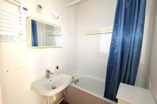 une salle de bain blanche avec un lavabo et une baignoire dans l'établissement Villa Tao a quelques pas de la plage, à Torreilles