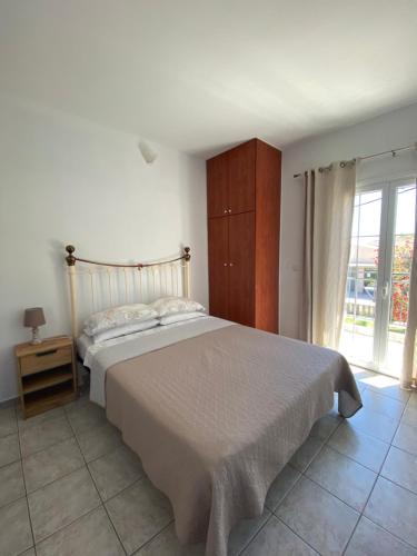 a bedroom with a bed and a large window at Annalisa Studio & Apartments in Skala Kefalonias