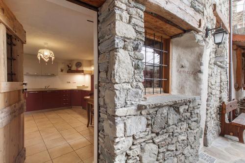 an open door into a kitchen with a stone wall at Maison Peroulaz Charvensod in Charvensod