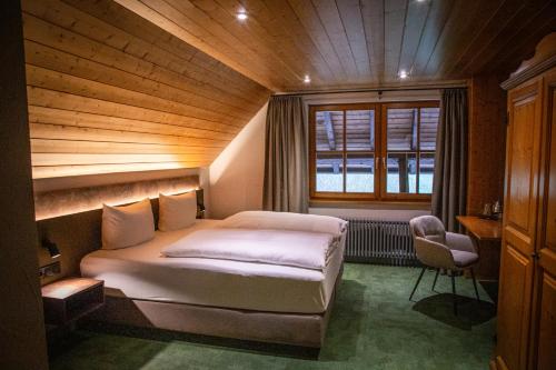 a bedroom with a bed in a room with a window at Hotel Hofgut Sternen - Ravennaschlucht in Breitnau