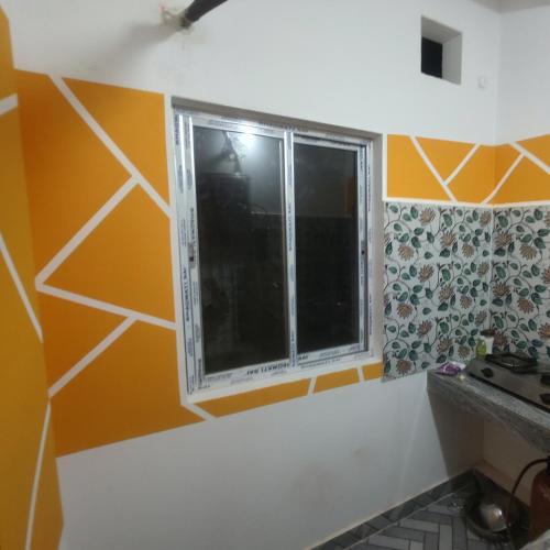 a window in a kitchen with orange and yellow walls at ABDB 1bhk in Guwahati