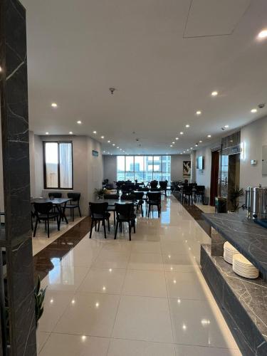 a restaurant with tables and chairs in a building at Perlina Hotel Erbil in Erbil