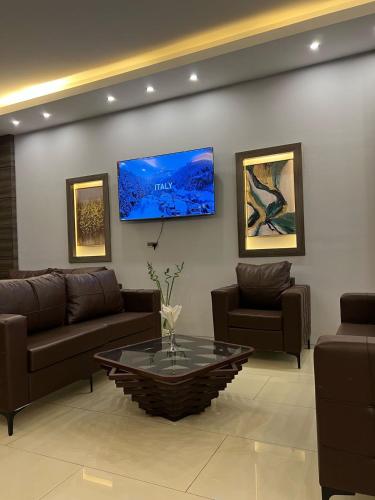 a living room with couches and a coffee table at Perlina Hotel Erbil in Erbil