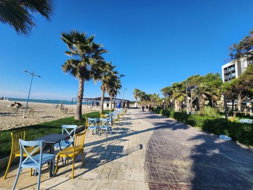 a row of tables and chairs on the beach at Seaside Bliss in Qerret Beach in Golem