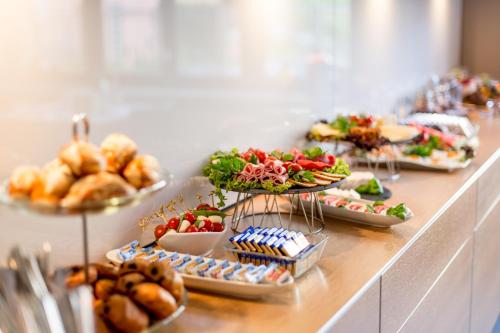 a buffet line with plates of food and pastries at Hotel Villa Vinum Cochem in Cochem