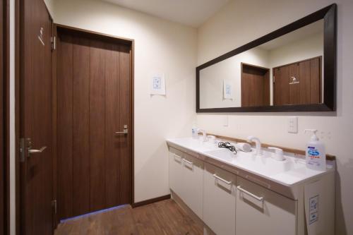 a bathroom with a sink and a mirror at YUKARA LEAF OLDGE - Vacation STAY 29727v in Ōnuma