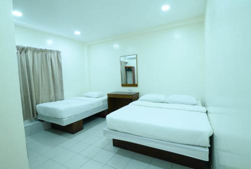 
A bed or beds in a room at Mersing Hotel
