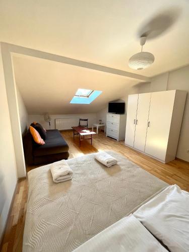 a bedroom with a large bed and a couch at Agapella Apartamemty- Villa Agapella 250m from the beach in Sopot