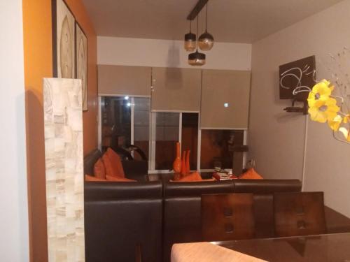 a living room with a black couch with orange pillows at Depa amueblado y Bonita in Buenavista