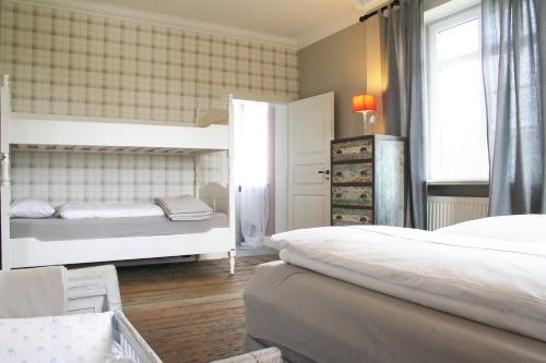 a bedroom with two beds and a window at Gutshaus Volzrade Hotel & Ferienwohnungen in Elbnähe in Lübtheen