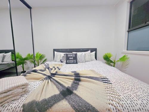 1 dormitorio con 1 cama con manta y almohadas en Eden - Kaws 伊甸园 - 潮熊, en Ascot Park