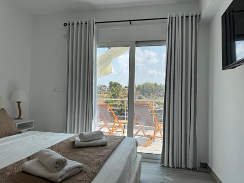 a bedroom with a bed and a balcony with a view at D & A Land luxury house in Alonnisos