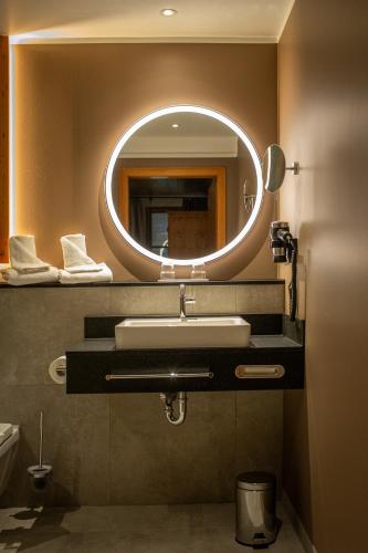 a bathroom with a sink and a mirror at Hotel Hofgut Sternen - Ravennaschlucht in Breitnau
