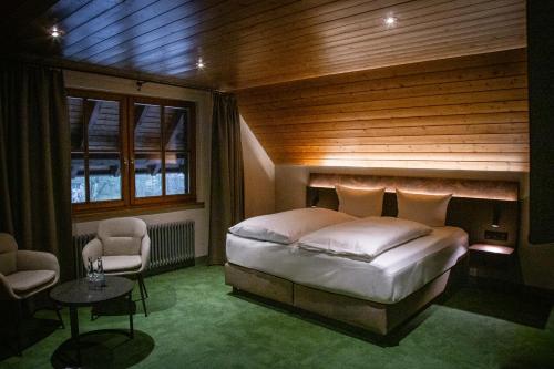 a bedroom with a bed and a table and chairs at Hotel Hofgut Sternen - Ravennaschlucht in Breitnau