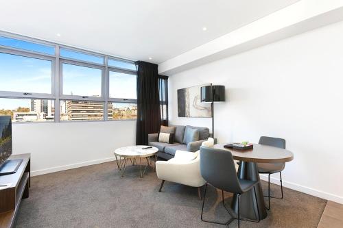 a living room with a couch and a table at KozyGuru | Chatswood | Convenient 1 Bed Studio Apt in Sydney