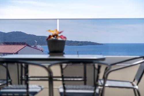 a table with a potted plant on top of the ocean at Aeli Vista Apartments in Neos Marmaras
