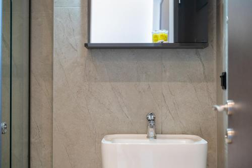 a bathroom with a white sink and a mirror at Aeli Vista Apartments in Neos Marmaras