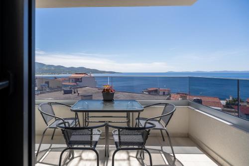 a table and chairs on a balcony with a view of the ocean at Aeli Vista Apartments in Neos Marmaras