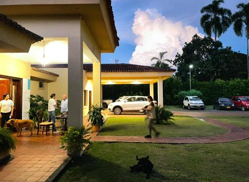 a man standing outside of a house with a dog at La Casa de los Libros in Pereira