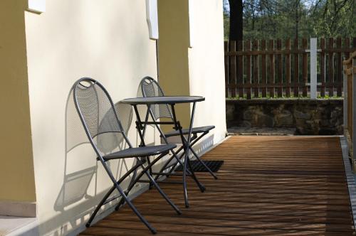 two chairs and a table on a porch at Mlýn Kamenice in Klučenice
