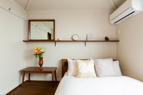a bedroom with a bed and a mirror and a table at HOTEL RIN TOKYO - Private Townhouse - in Tokyo