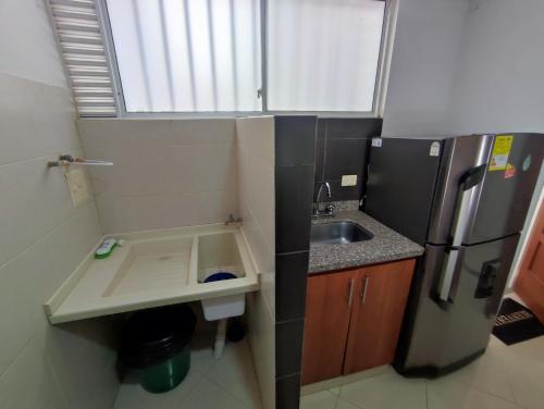 a small kitchen with a sink and a refrigerator at Apacible Loft San Alonso in Bucaramanga