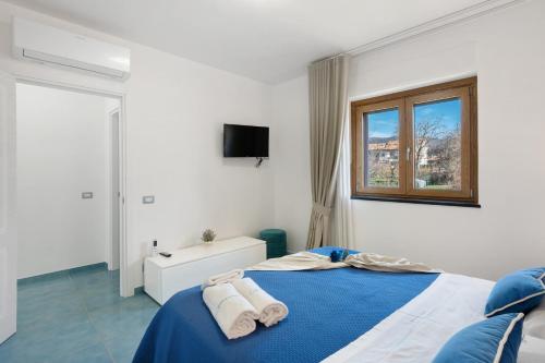 アジェーロラにあるLa Dimora Dei Nonni Apartmentsのベッドルーム1室(ブルーベッド1台、タオル付)