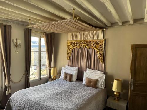 une chambre avec un lit à baldaquin dans l'établissement Place Dauphine, à Paris