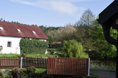 a fence in front of a white house at Mlýn Kamenice in Klučenice
