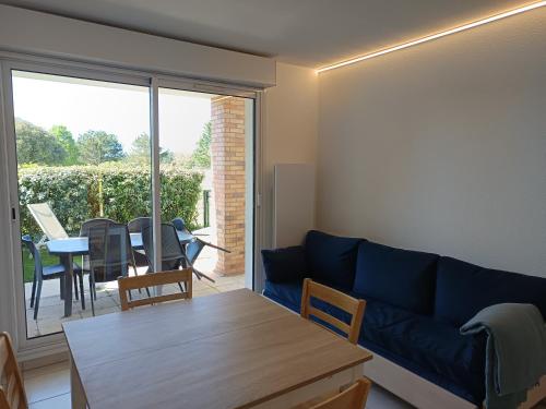 a living room with a blue couch and a table at T2 Parc du Golf in Pornic