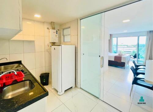 a kitchen with a sink and a refrigerator at Fortaleza Sul Flats Service in Fortaleza