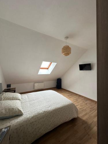 a bedroom with a large bed and a skylight at L'étape Giennoise in Gien
