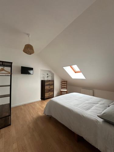 a bedroom with a large white bed and a skylight at L'étape Giennoise in Gien