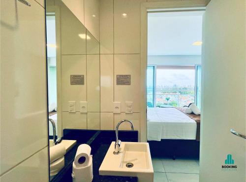 a bathroom with a sink and a bed and a mirror at Fortaleza Sul Flats Service in Fortaleza