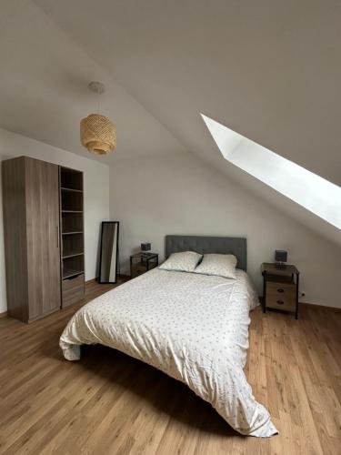 a bedroom with a bed with a white comforter at L'étape Giennoise in Gien
