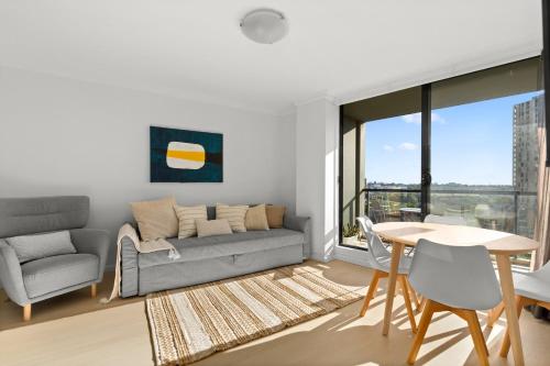 a living room with a couch and a table at KozyGuru | Haymarket | Cozy 2-Bedroom Apartment in Sydney