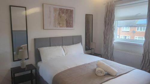 a bedroom with a white bed and a window at South Shields Executive Apartment in South Shields