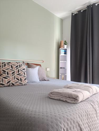 una camera da letto con un grande letto con una tenda grigia di Loano Experience - 70m dal mare a Loano