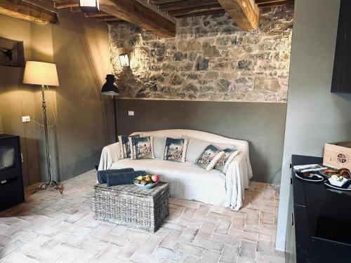 a bedroom with a bed and a stone wall at Conti di San Bonifacio - Tuscan Townhouse in Montemassi
