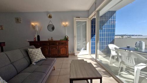 un salon avec un canapé et une table dans l'établissement Saint Georges de Didonne - CONFORT SIMPLE pour cet APPARTEMENT face à la PLAGE, à Saint-Georges-de-Didonne