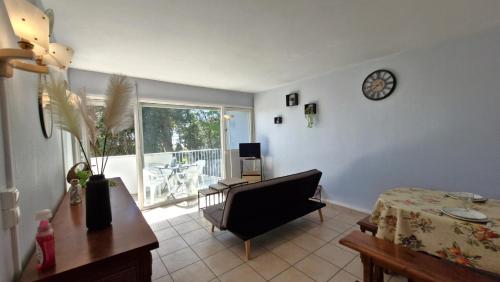 un salon avec une chaise et un réveil sur le mur dans l'établissement Saint Georges de Didonne - CONFORT SIMPLE pour cet APPARTEMENT face à la PLAGE, à Saint-Georges-de-Didonne