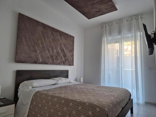 a bedroom with a bed and a painting on the wall at La Casa di Mimi in Monopoli