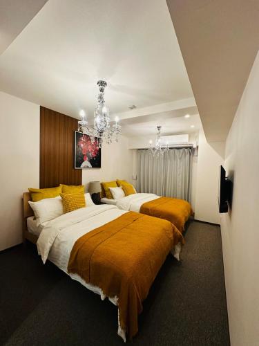 two beds in a bedroom with a chandelier at Leopard Shinsaibashi 心斎橋 505 in Osaka